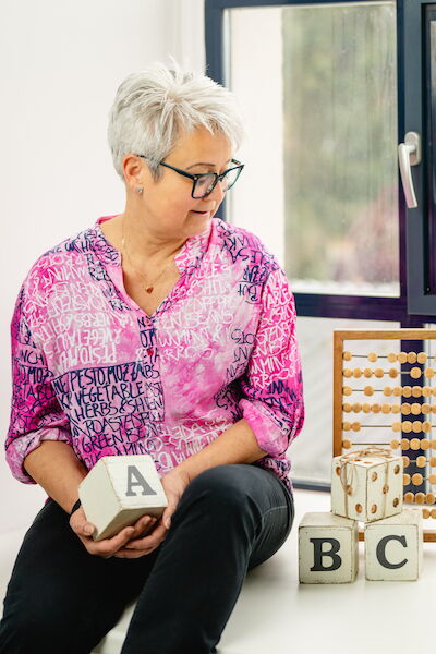 Sabine Robar mit Buchstabenwürfeln und Rechenrahmen